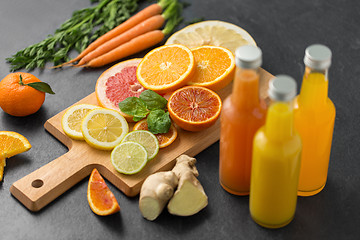 Image showing glass bottles of fruit juice on slate table top