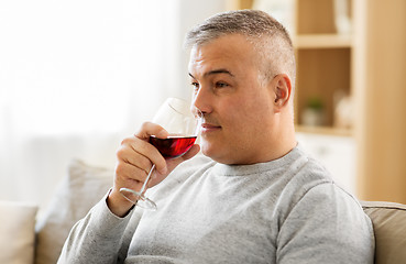 Image showing man drinking red wine from glass at home