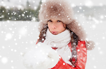 Image showing happy woman with snow in winter fur hat outdoors