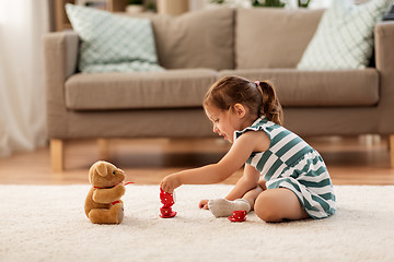 Image showing little girl playing with toy tea set at home