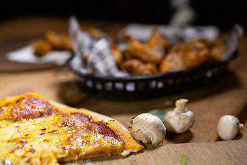 Image showing Rustic bistro pub food pizza and basket chicken wings