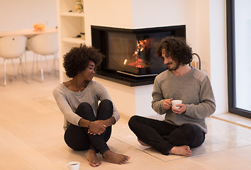 Image showing multiethnic couple  in front of fireplace