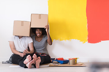 Image showing young multiethnic couple playing with cardboard boxes