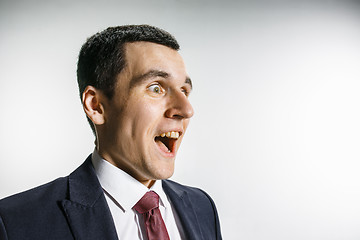 Image showing Three-quarter portrait of a businessman with surprised and smiling face. Confident professional with piercing look in the foreground of the camera.