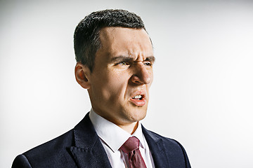 Image showing Three-quarter portrait of a businessman with disgust face. Confident professional with piercing look in the foreground of the camera.