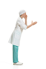 Image showing Beautiful young woman in white coat posing at studio. Full length studio shot isolated on white.