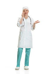 Image showing Beautiful young woman in white coat posing at studio. Full length studio shot isolated on white.