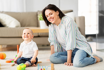 Image showing happy mother with little baby son playing at home