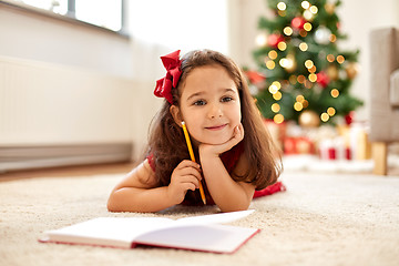 Image showing little girl writing christmas wish list at home
