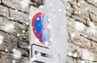 Image showing ice-covered no stopping road sign over wall