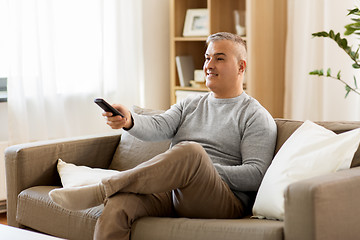 Image showing man with remote control watching tv at home