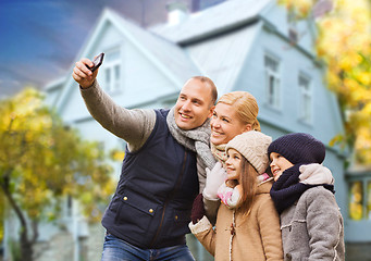 Image showing family takes autumn selfie by cellphone over house