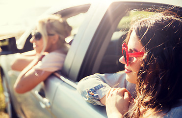 Image showing happy teenage girls or women in car at seaside