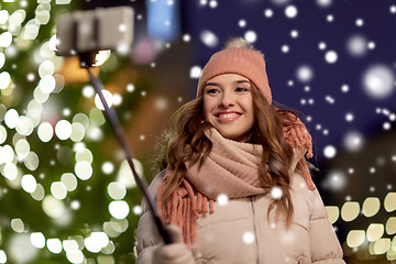 Image showing young woman taking selfie over christmas tree