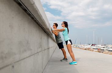 Image showing couple with fitness trackers exercising outdoors