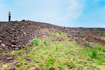 Image showing The worker is at the top of the rock heap in his quarry