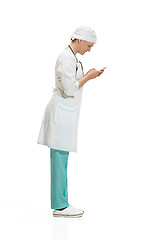 Image showing Beautiful young woman in white coat posing at studio. Full length studio shot isolated on white.