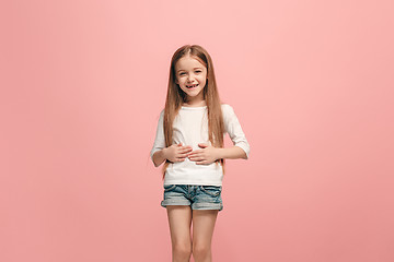 Image showing The happy teen girl standing and smiling against pink background.