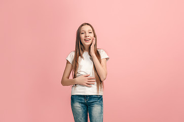 Image showing The happy teen girl standing and smiling against pink background.