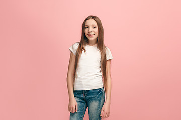 Image showing The happy teen girl standing and smiling against pink background.