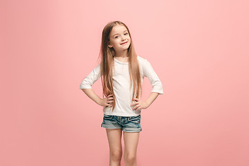 Image showing The happy teen girl standing and smiling against pink background.