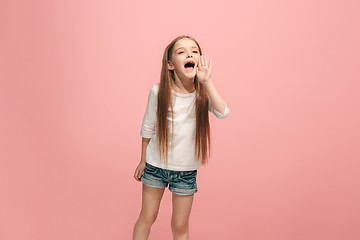 Image showing Isolated on pink young casual teen girl shouting at studio