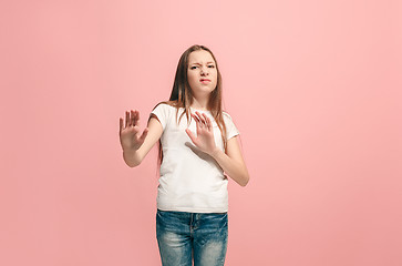 Image showing Doubtful pensive teen girl rejecting something against pink background