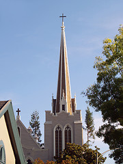 Image showing Christian church steeple with blue sky and tree