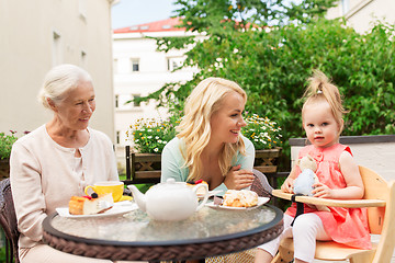 Image showing woman with daughter and senior mother at cafe