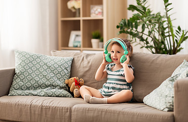 Image showing redhead baby girl in headphones listening to music