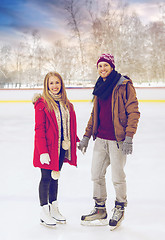 Image showing happy couple holding hands on outdoor skating rink