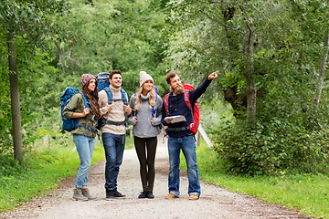 Image showing friends or travelers hiking with backpacks and map