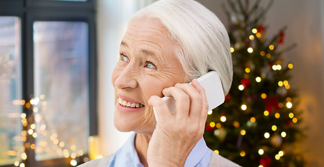 Image showing senior woman with smartphone calling at home