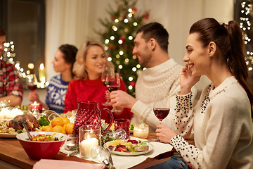 Image showing happy friends having christmas dinner at home