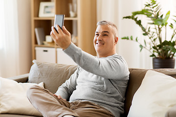 Image showing man taking selfie by smartphone at home