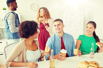 Image showing happy friends or team eating at office