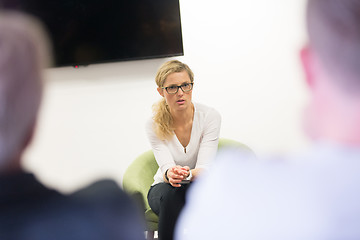 Image showing Female candidate presenting her CV in front of business job recuters during job interview in office.