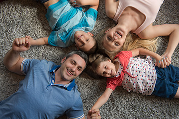 Image showing happy family lying on the floor