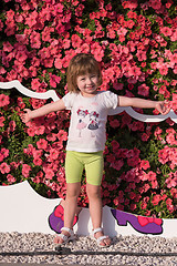 Image showing little cute girl in a flower garden