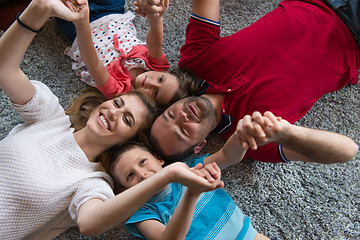 Image showing happy family lying on the floor