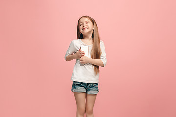 Image showing The happy teen girl standing and smiling against pink background.