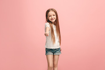 Image showing The happy teen girl pointing to you, half length closeup portrait on pink background.