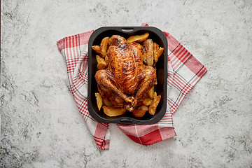 Image showing Roasted chicken or turkey with potatoes in black steel mold