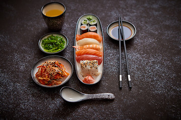 Image showing Asian food assortment. Various sushi rolls placed on ceramic plates