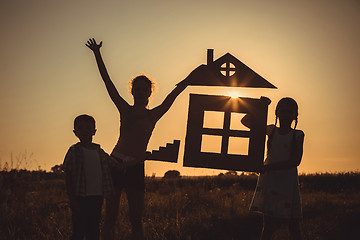 Image showing Happy children standing on the field at the sunset time.