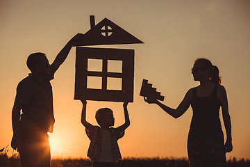 Image showing Happy family standing on the field at the sunset time.