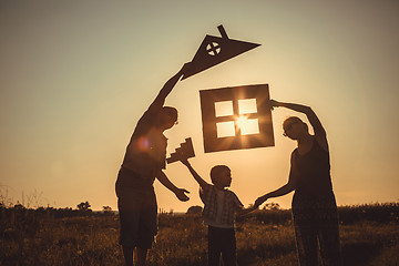 Image showing Happy family standing on the field at the sunset time.