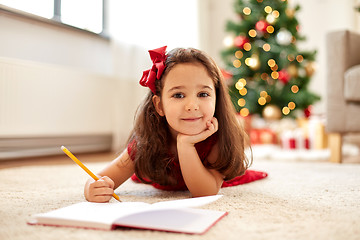 Image showing little girl writing christmas wish list at home