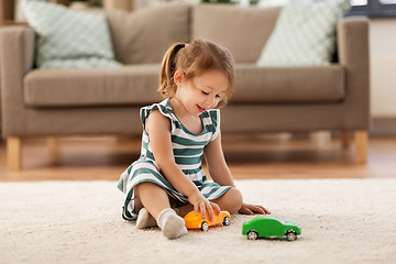 Image showing happy baby girl playing with toy car at home