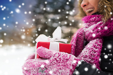 Image showing close up of woman with christmas gift outdoors